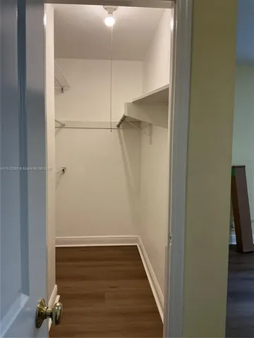 a view of closet with wooden floor