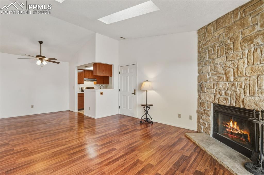 918 Tenderfoot Hill Road, Unit 202 Colorado Springs, CO 80906 - Photo 12 of 48 a view of empty room with wooden floor fireplace and a chandelier