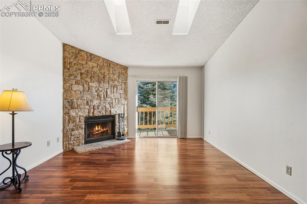 918 Tenderfoot Hill Road, Unit 202 Colorado Springs, CO 80906 - Photo 6 of 48 a view of an empty room with a fireplace and a window
