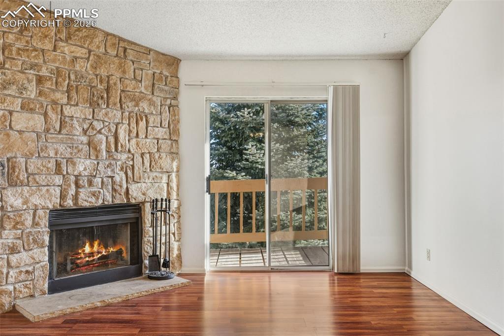 918 Tenderfoot Hill Road, Unit 202 Colorado Springs, CO 80906 - Photo 8 of 48 a view of an empty room with wooden floor fireplace and a window
