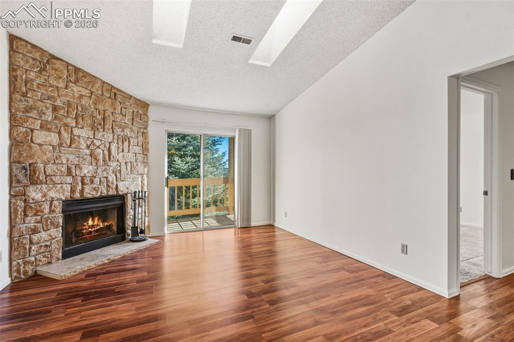 918 Tenderfoot Hill Road, Unit 202 Colorado Springs, CO 80906 - Photo 9 of 48 a view of an empty room with wooden floor fireplace and a window