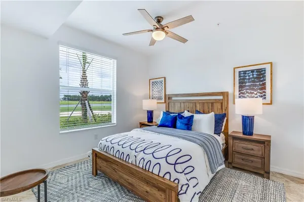a bedroom with a bed a chandelier and a window