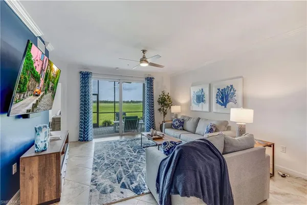 a living room with furniture a flat screen tv and a large window