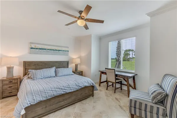 a bedroom with a bed a chandelier and a window