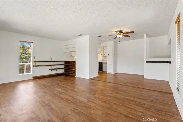 an empty room with a window and a ceiling fan