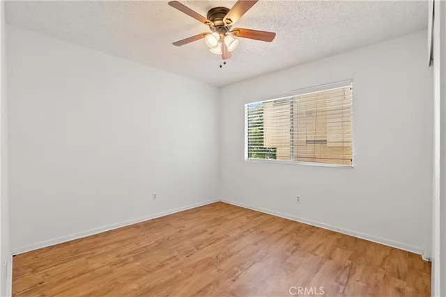 a view of a room with a ceiling fan and wooden floor