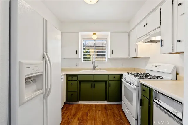 a kitchen with a sink a stove cabinets and a refrigerator
