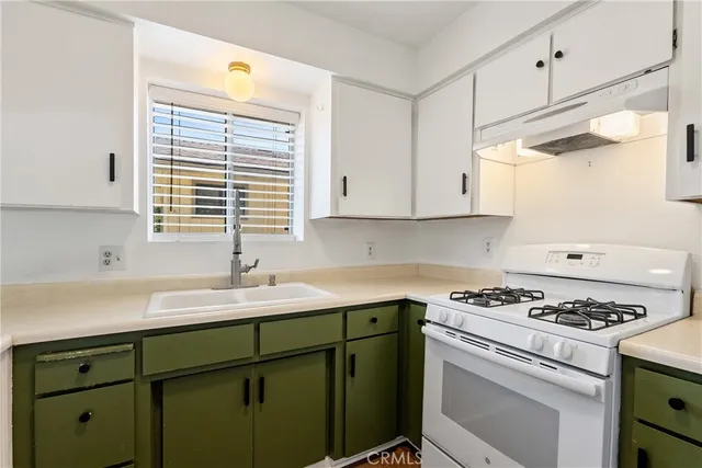 a kitchen with cabinets appliances and a window