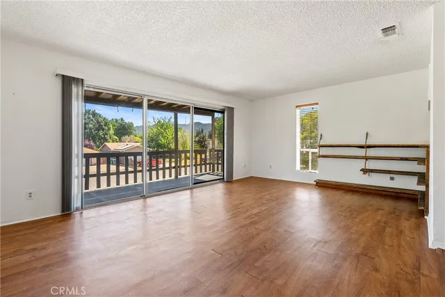 a view of a room with wooden floor and large window