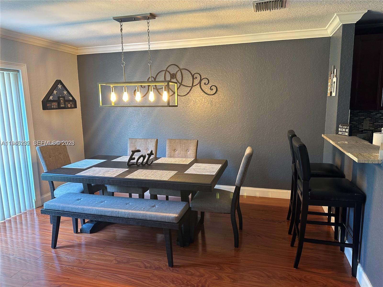 9891 Northwest 24th Street Sunrise, FL 33322 - Photo 2 of 8 a view of a dining room with furniture and wooden floor