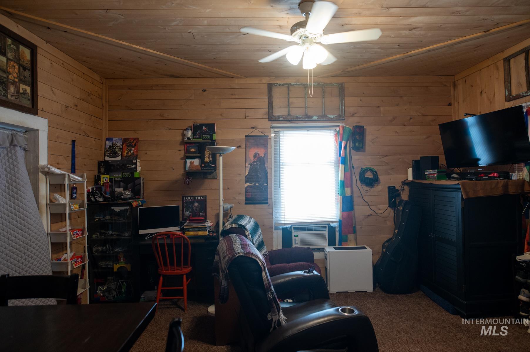 736 East Main Street Weiser, ID 83672 - Photo 30 of 33 Wood-paneled room featuring a ceiling fan with light, single window, and textile wall hangings