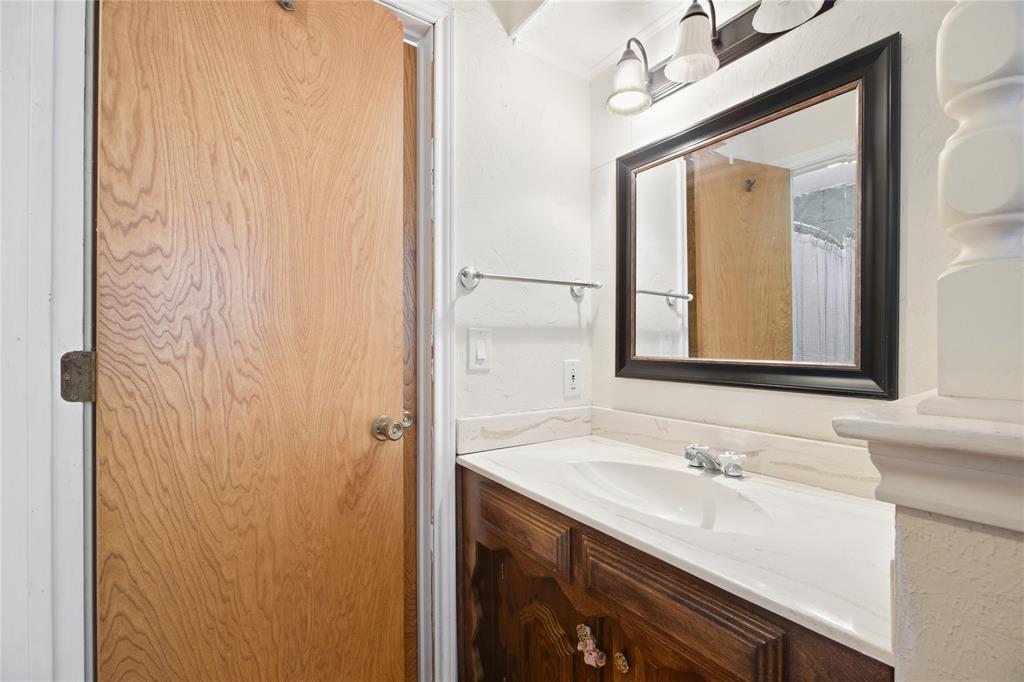 1320 Cheyenne Road Lewisville, TX 75077 - Photo 16 of 27 Wood-finish vanity with an integrated sink and chrome faucet