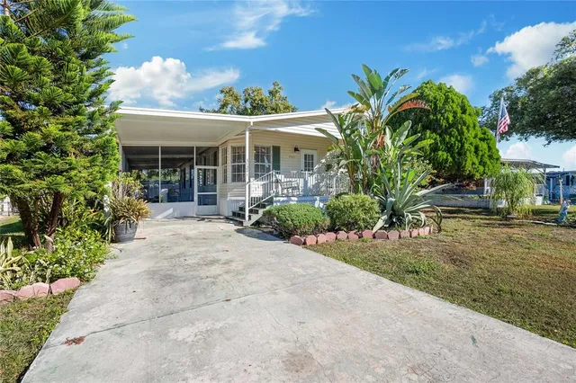 a view of a house with potted plants and a yard