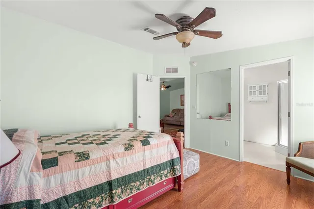 a bedroom with a bed a dresser and a chandelier