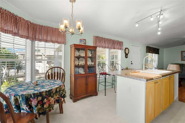 a view of a dining room with furniture a chandelier and wooden floor