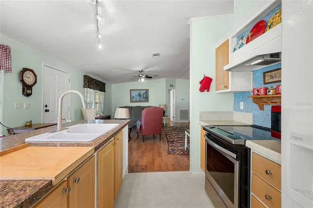 a kitchen with granite countertop a sink stove and cabinets