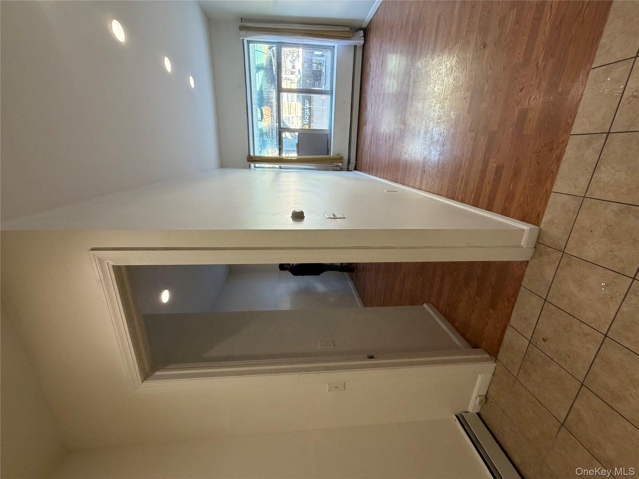 86-28 80th Street Queens, NY 11421 - Photo 4 of 5 a view of a hallway with wooden floor and windows