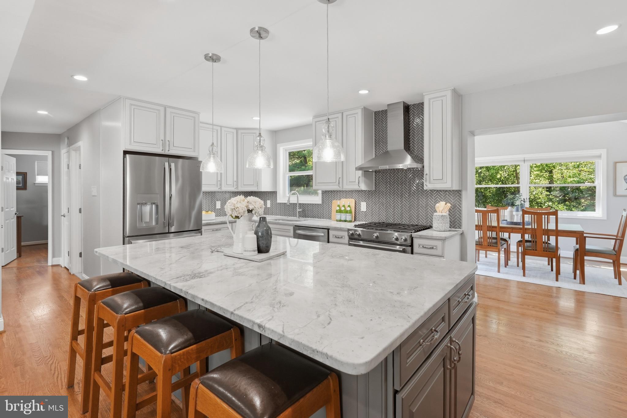 7006 Barnack Drive Springfield, VA 22152 - Photo 12 of 56 a open kitchen with stainless steel appliances granite countertop a stove a refrigerator a oven a sink a dining table and chairs with wooden floor