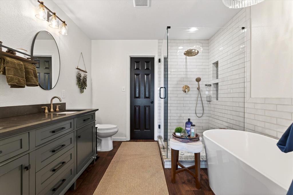 7675 Michael Road Sanger, TX 76266 - Photo 25 of 40 a spacious bathroom with a granite countertop sink a toilet a mirror and shower