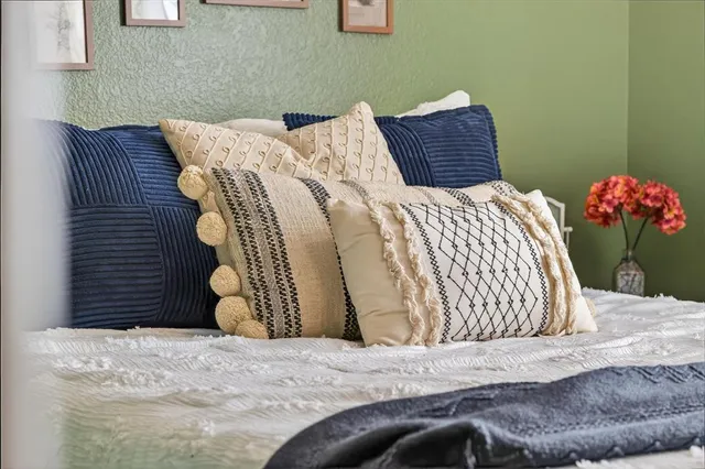 a bedroom with a bed and a painting on the wall