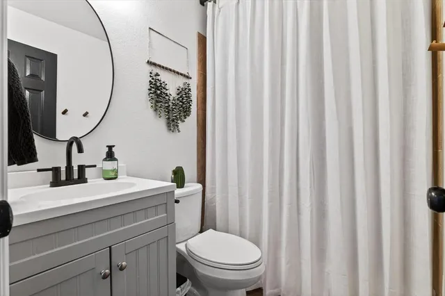 a bathroom with a toilet a sink and a mirror
