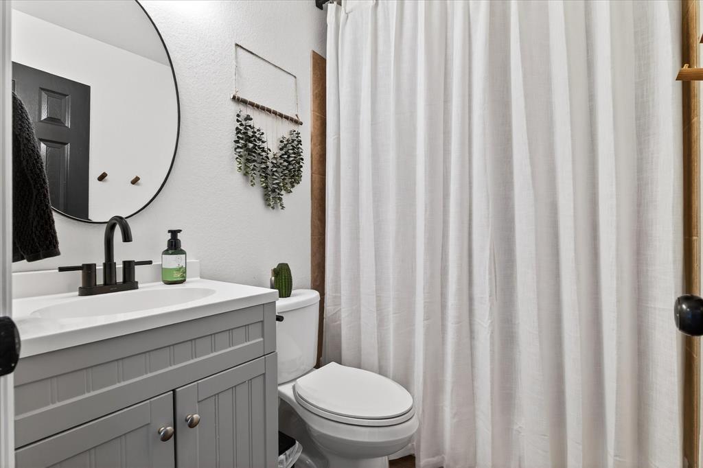 7675 Michael Road Sanger, TX 76266 - Photo 29 of 40 a bathroom with a toilet a sink and a mirror