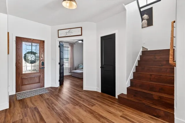 a view of an entryway with wooden floor and door