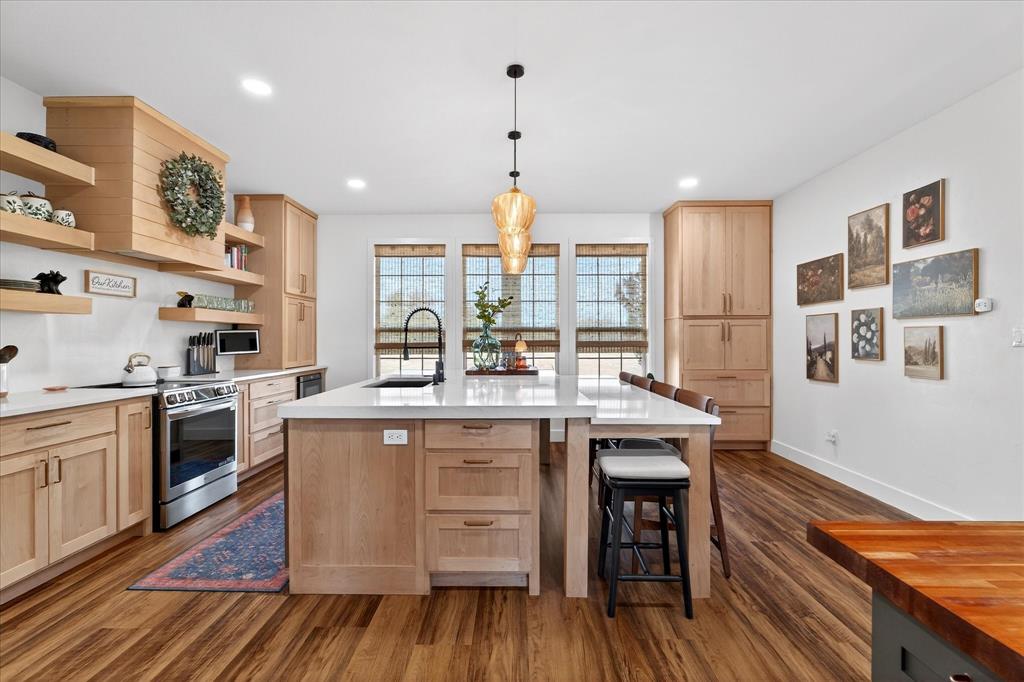 7675 Michael Road Sanger, TX 76266 - Photo 10 of 40 a kitchen with stainless steel appliances granite countertop wooden floors and wooden cabinets
