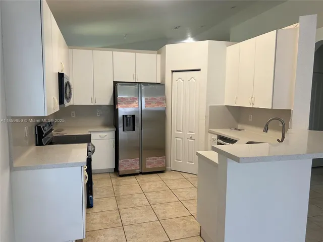 a kitchen with stainless steel appliances a refrigerator sink and cabinets