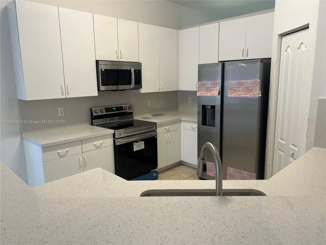 a kitchen with stainless steel appliances granite countertop a refrigerator stove and microwave