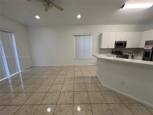 a kitchen with stainless steel appliances a sink a stove a microwave a sink a counter top space and cabinets