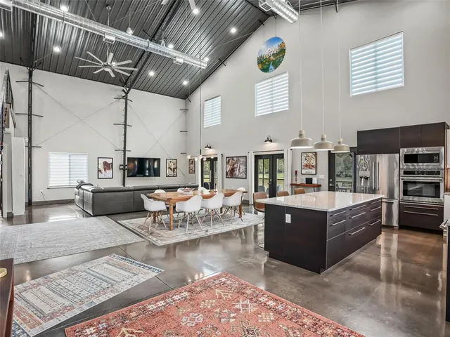 a kitchen with stainless steel appliances a dining table chairs and a window