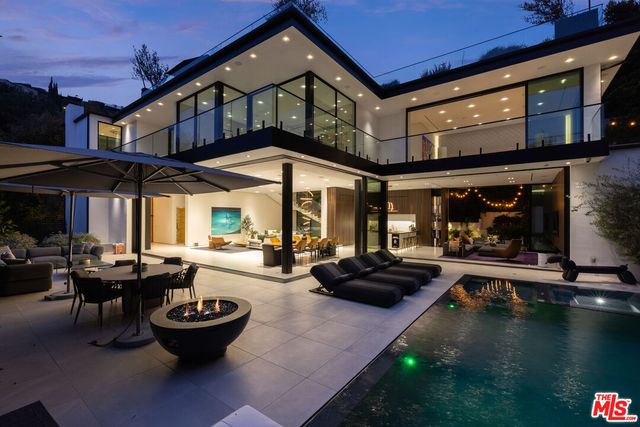 a view of a patio with table and chairs potted plants and a fireplace