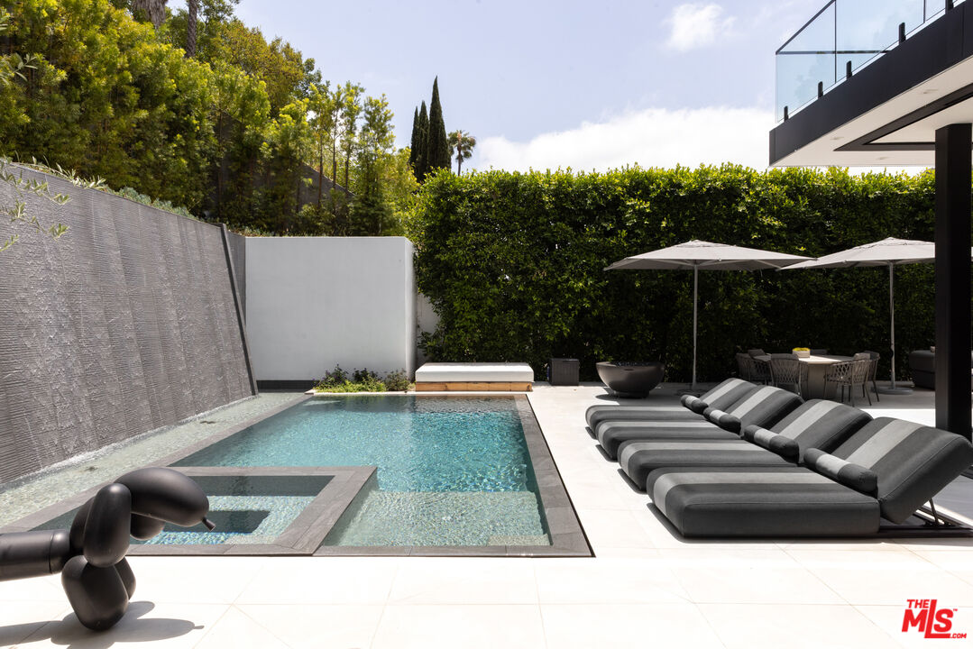 1488 Rising Glen Road Los Angeles, CA 90069 - Photo 12 of 37 a view of swimming pool with lounge chair and dinning table under an umbrella