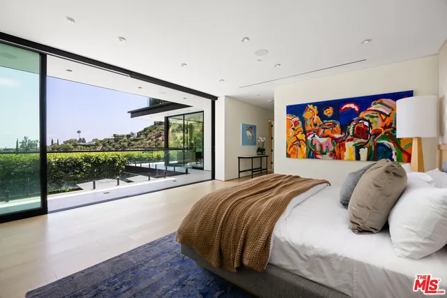 a bed sitting in a bedroom next to a large window