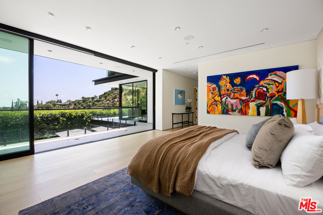 1488 Rising Glen Road Los Angeles, CA 90069 - Photo 15 of 37 a bed sitting in a bedroom next to a large window