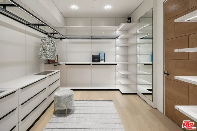 a kitchen with white cabinets and wooden floor