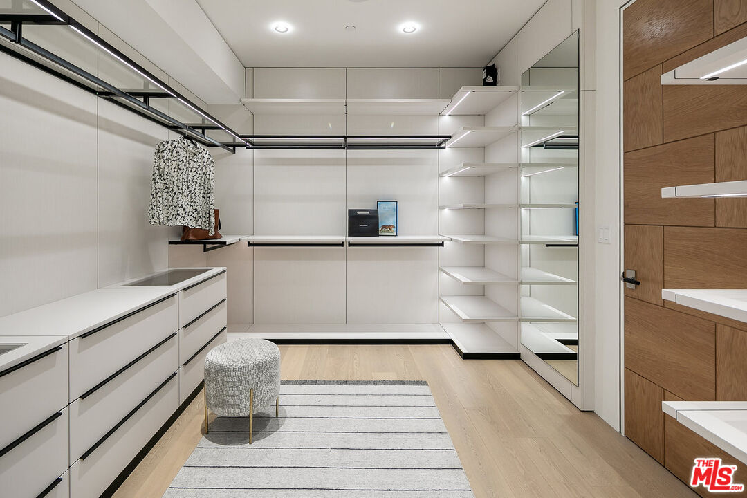 1488 Rising Glen Road Los Angeles, CA 90069 - Photo 17 of 37 a kitchen with white cabinets and wooden floor