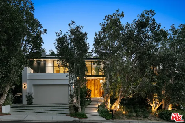 a front view of a house with a tree