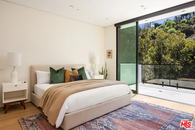 a large bed sitting in a bedroom next to a window