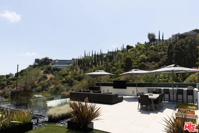 a patio with couches and a fire pit