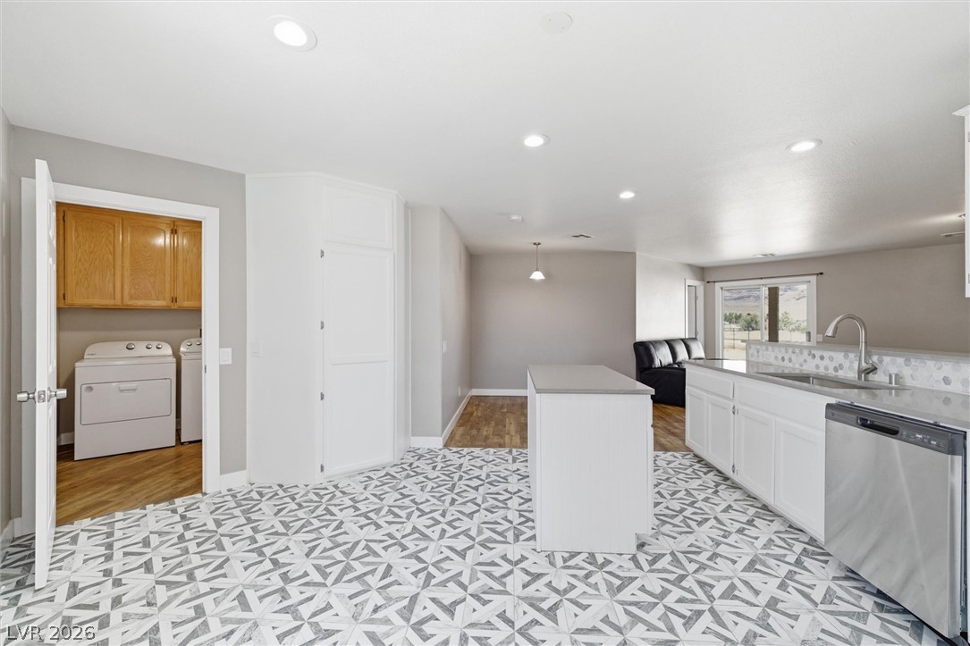 2780 West Simkins Road Pahrump, NV 89060 - Photo 17 of 40 A contemporary kitchen space boasts unique patterned tile flooring and efficient appliances, flowing into a bright laundry area.