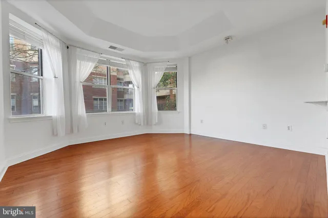 a view of an empty room with wooden floor