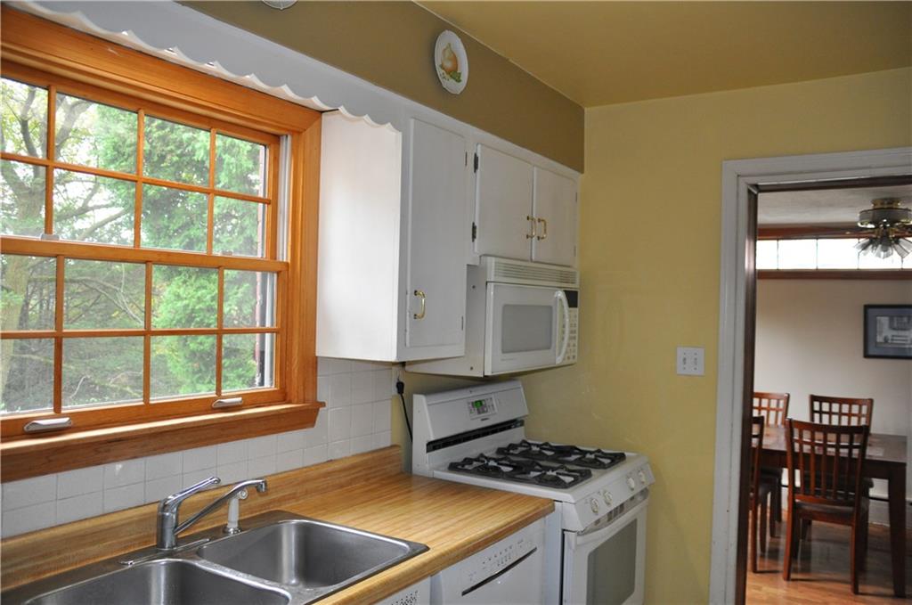 733 Greenlee Road Pittsburgh, PA 15227 - Photo 11 of 21 The kitchen features updated white appliances and cabinets.