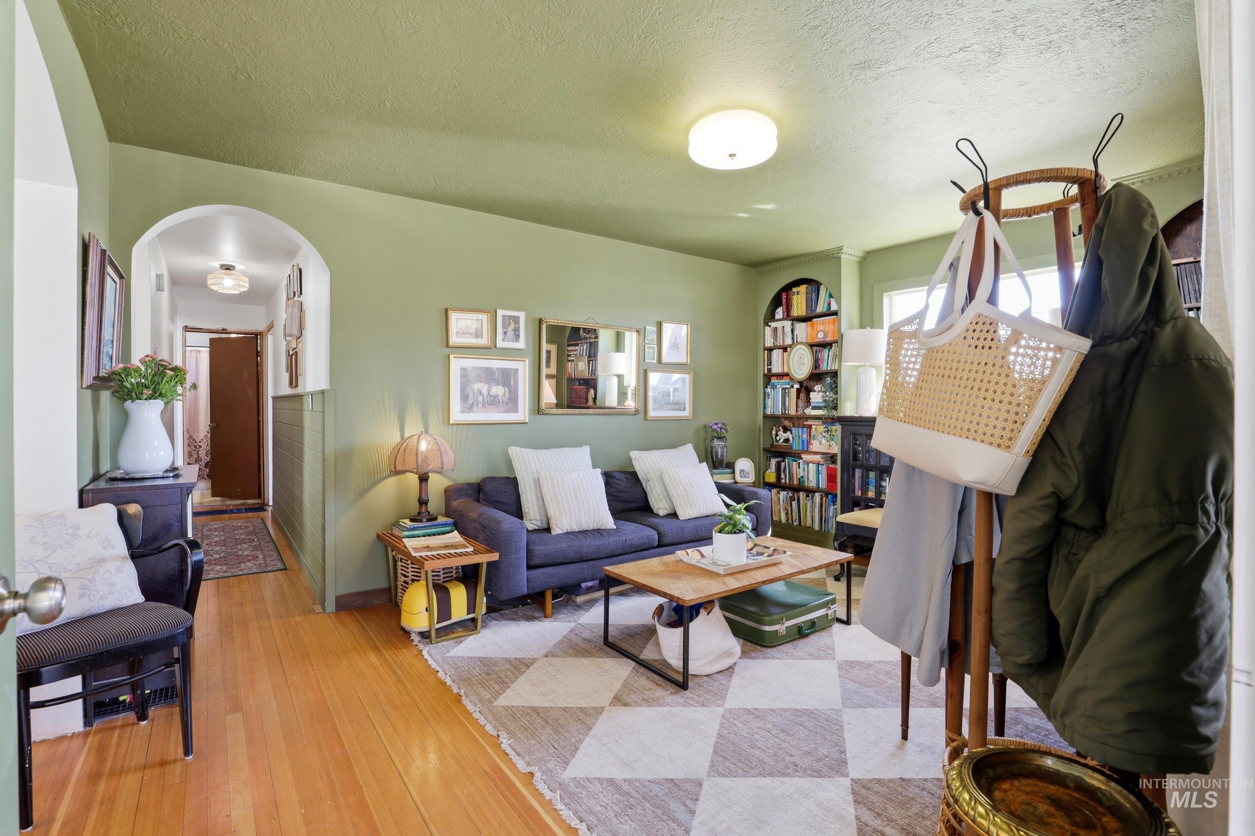 725 Elm Street Potlatch, ID 83855 - Photo 6 of 50 Living room with arched walkways, hardwood / wood-style flooring, and a textured ceiling