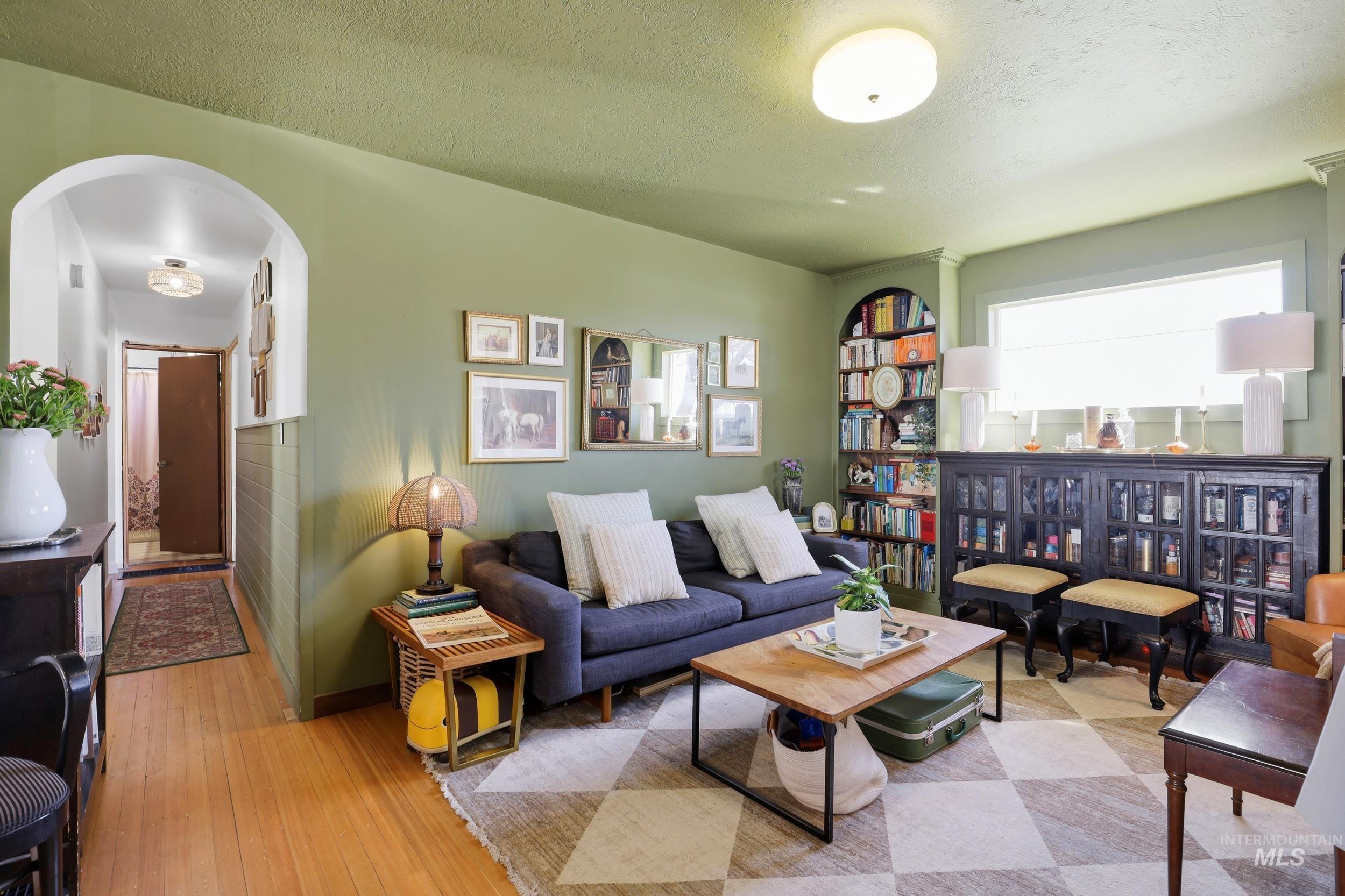 725 Elm Street Potlatch, ID 83855 - Photo 9 of 50 Living room with arched walkways, hardwood / wood-style flooring, and a textured ceiling