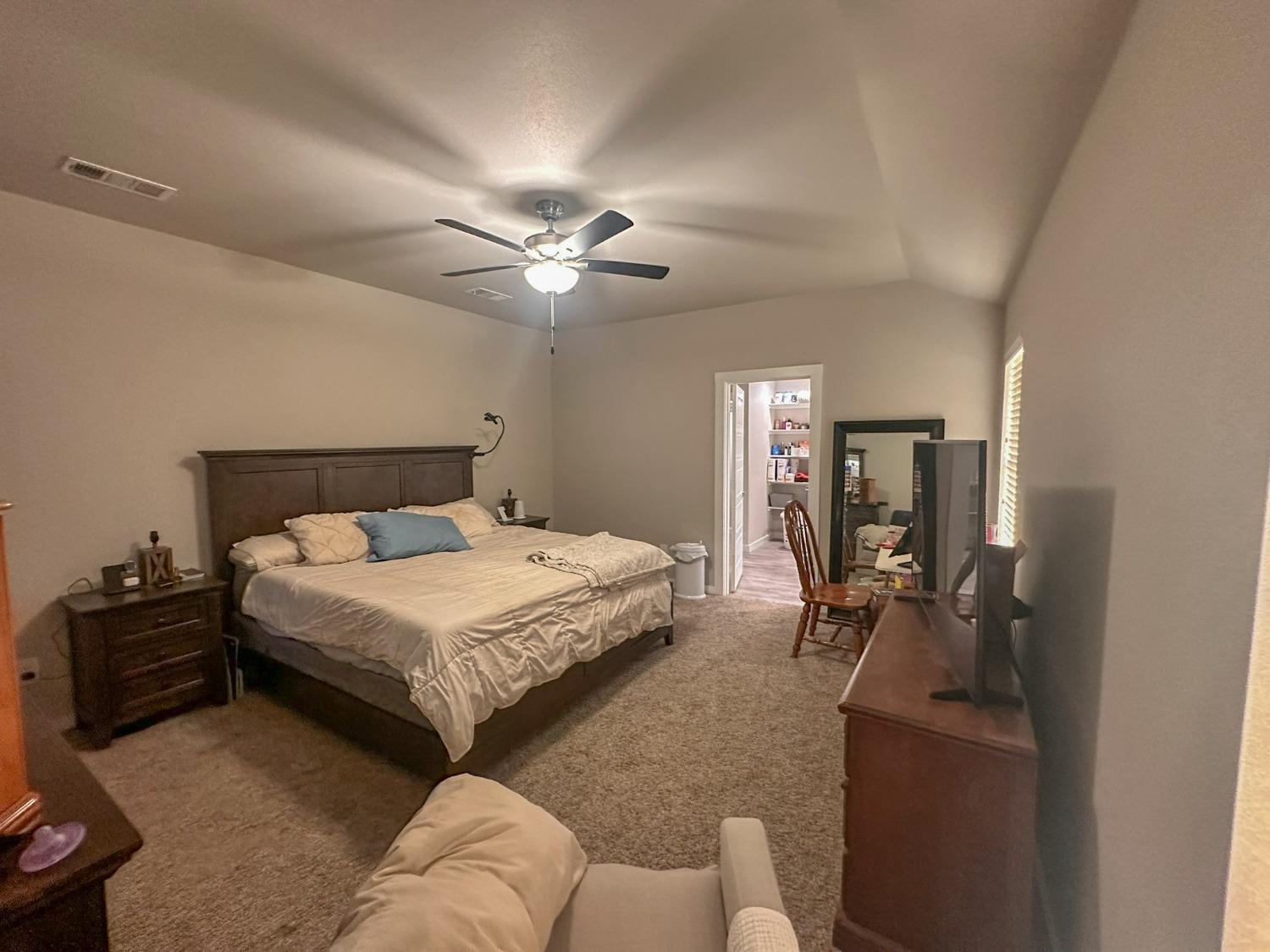 323 Ranger Street Wolfforth, TX 79382 - Photo 15 of 48 a bedroom with a bed couch and a chandelier