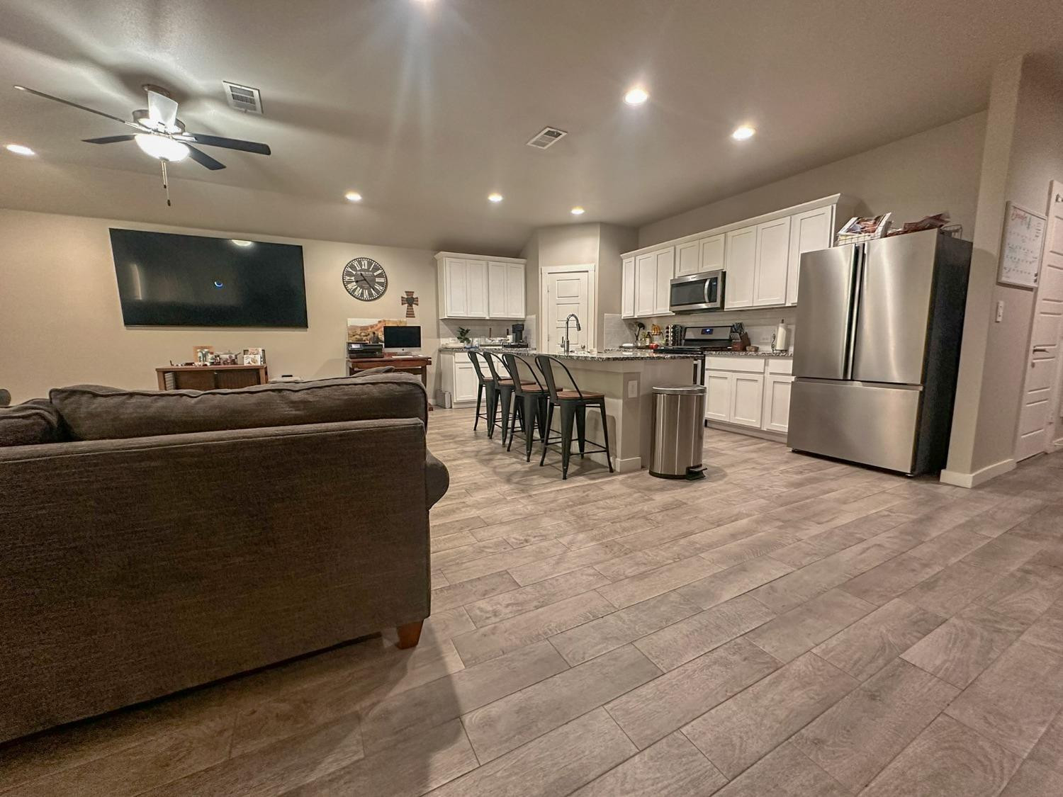 323 Ranger Street Wolfforth, TX 79382 - Photo 7 of 48 a living room with stainless steel appliances furniture a flat screen tv and a refrigerator