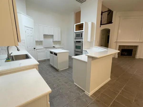 a room with kitchen island a sink a stove and a refrigerator