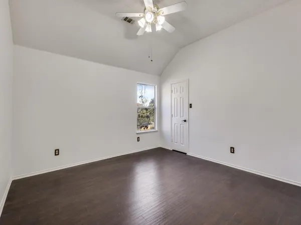 an empty room with a window and a ceiling fan